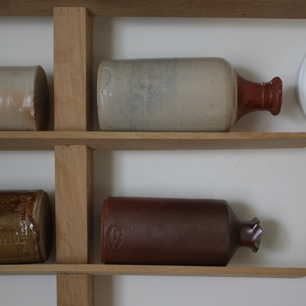 
                  
                    a collection of Antique stoneware bottles along with an oak display rack
                  
                