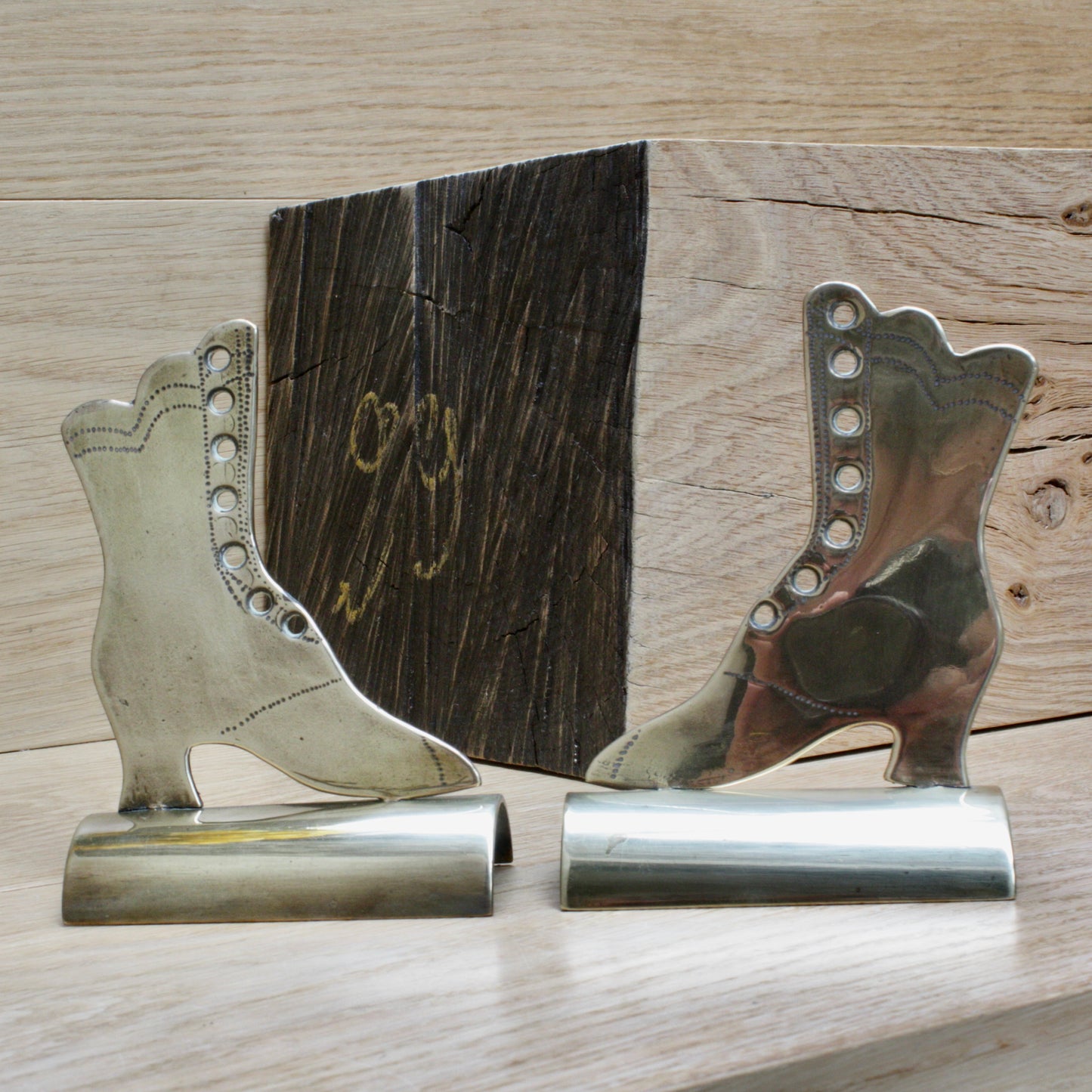 
                  
                    a pair of antique folk art mantlepiece brass boots
                  
                
