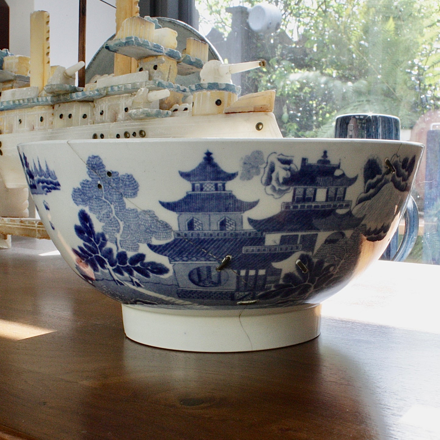 
                  
                    an antique willow pattern transfer ware tea service bowl
                  
                