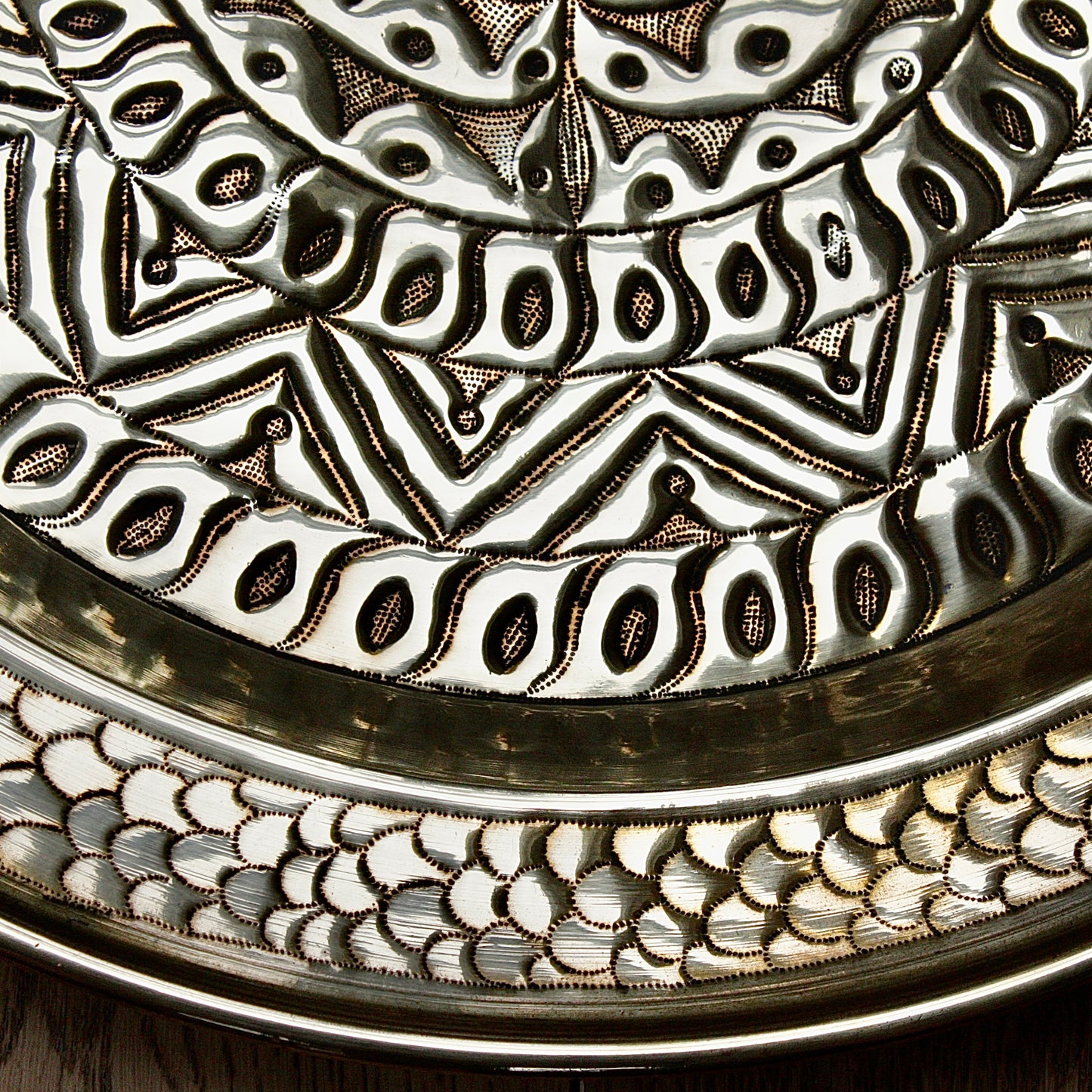 
                  
                    an embossed brass charger from old calabar  with geometric designs.
                  
                