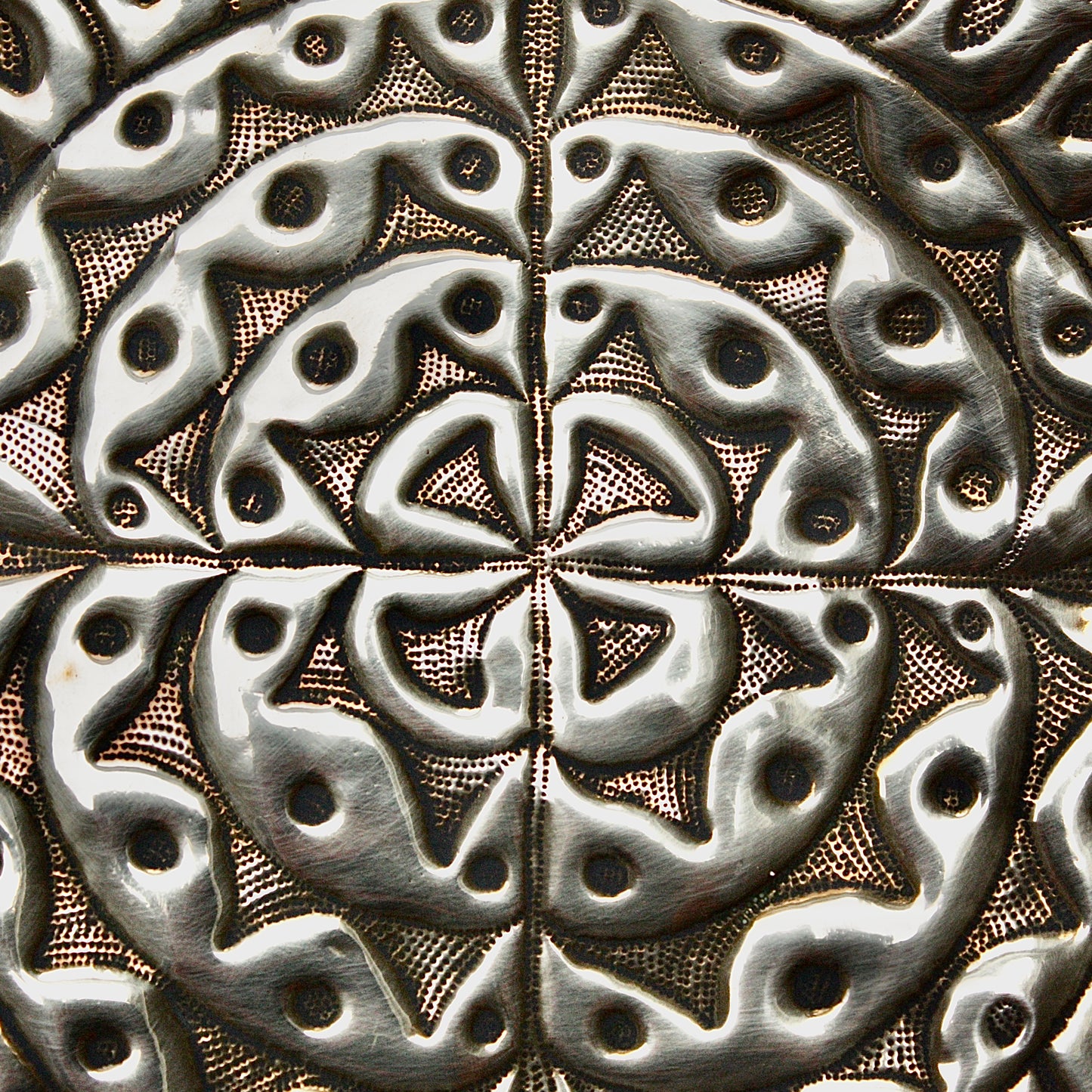 
                  
                    an embossed brass charger from old calabar  with geometric designs.
                  
                