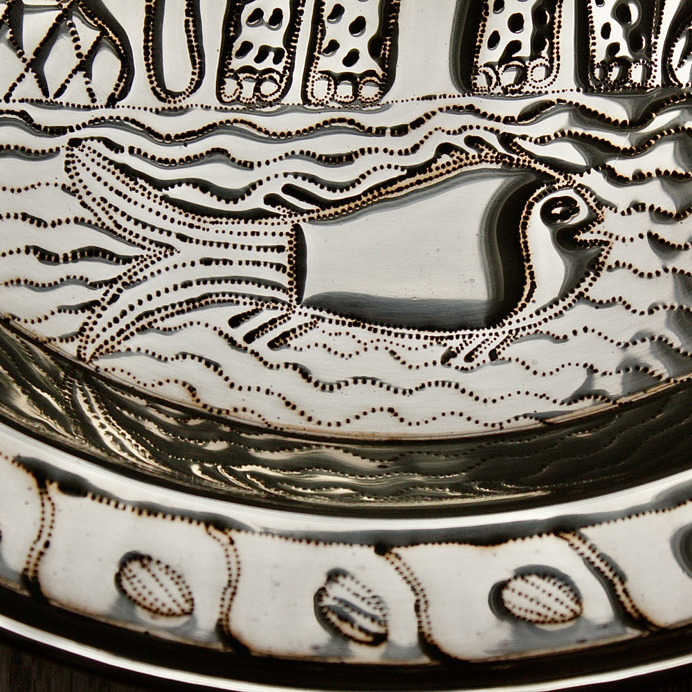 
                  
                    an african, efic brass charger with an elephant ,palm, flora and fish.
                  
                
