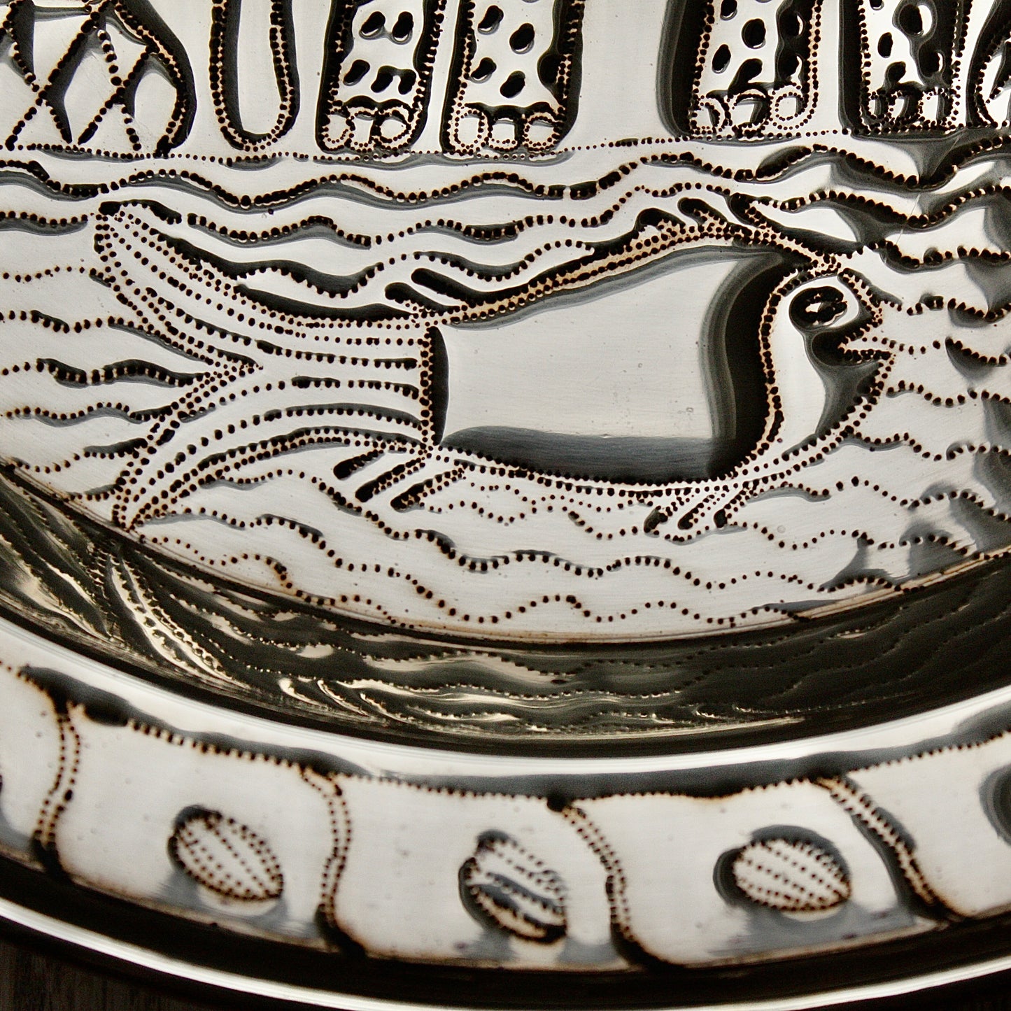 
                  
                    an african, efic brass charger with an elephant ,palm, flora and fish.
                  
                