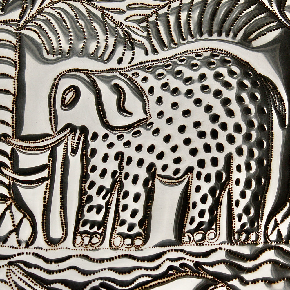 
                  
                    an african, efic brass charger with an elephant ,palm, flora and fish.
                  
                