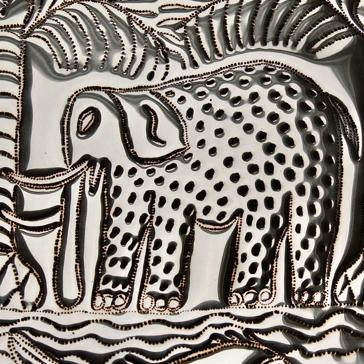 
                  
                    an african, efic brass charger with an elephant ,palm, flora and fish.
                  
                