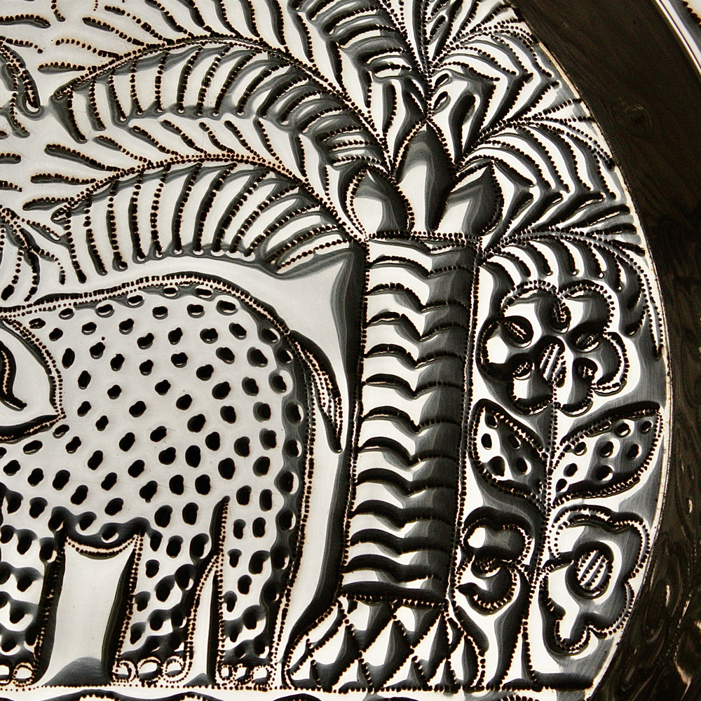 
                  
                    an african, efic brass charger with an elephant ,palm, flora and fish.
                  
                
