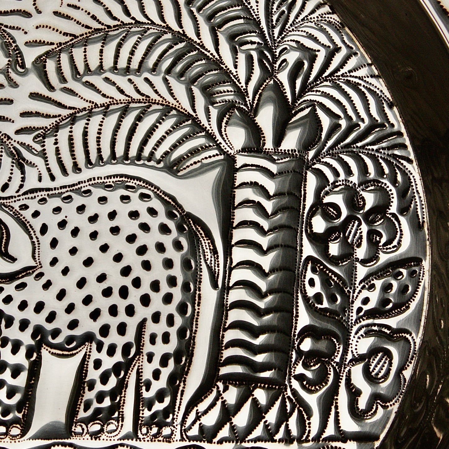 
                  
                    an african, efic brass charger with an elephant ,palm, flora and fish.
                  
                