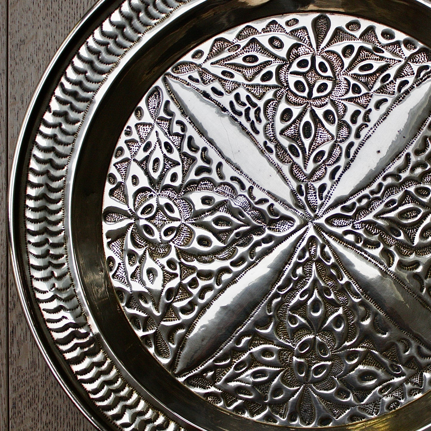 
                  
                    an antique brass embossed charger decorated with wild plants.
                  
                