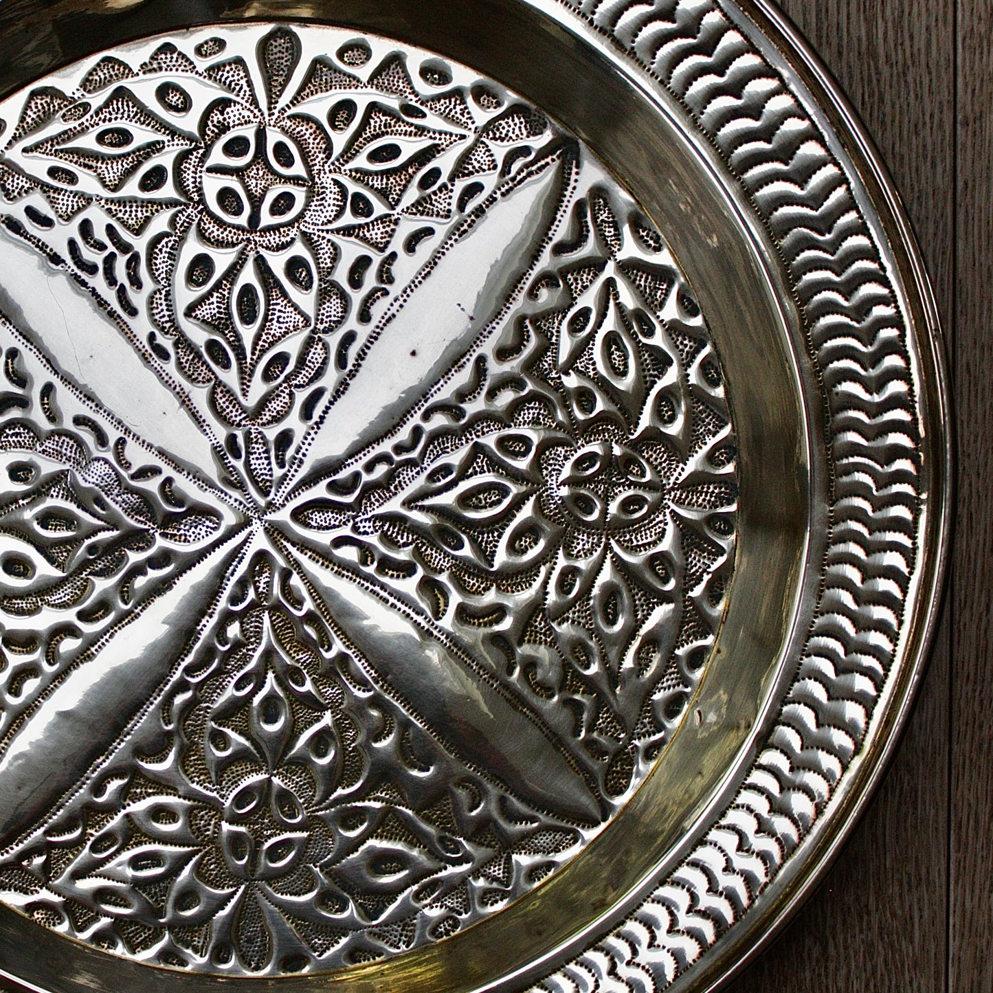 
                  
                    an antique brass embossed charger decorated with wild plants.
                  
                