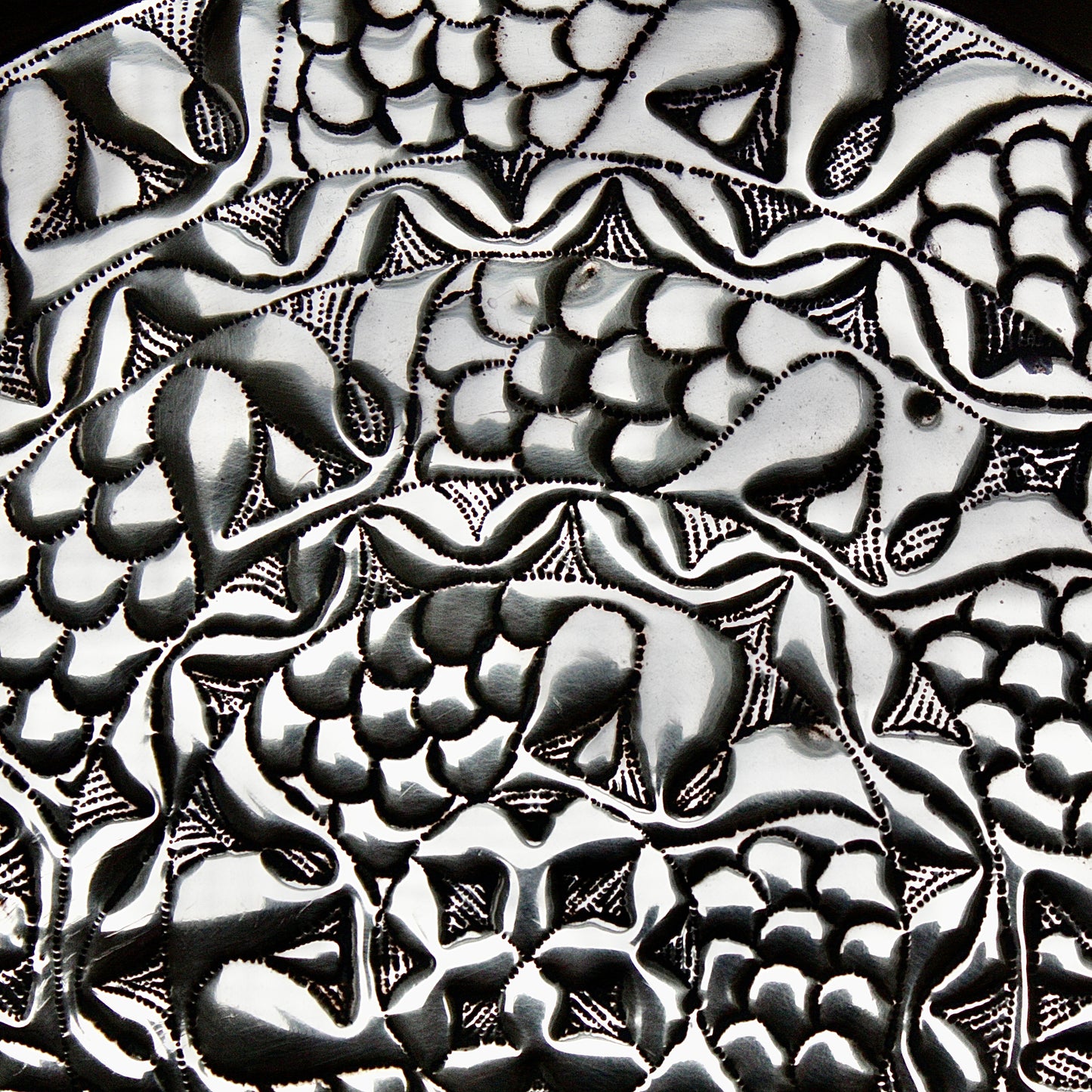 
                  
                    an embossed brass charger from old calabar with a radiating concentric pattern.
                  
                