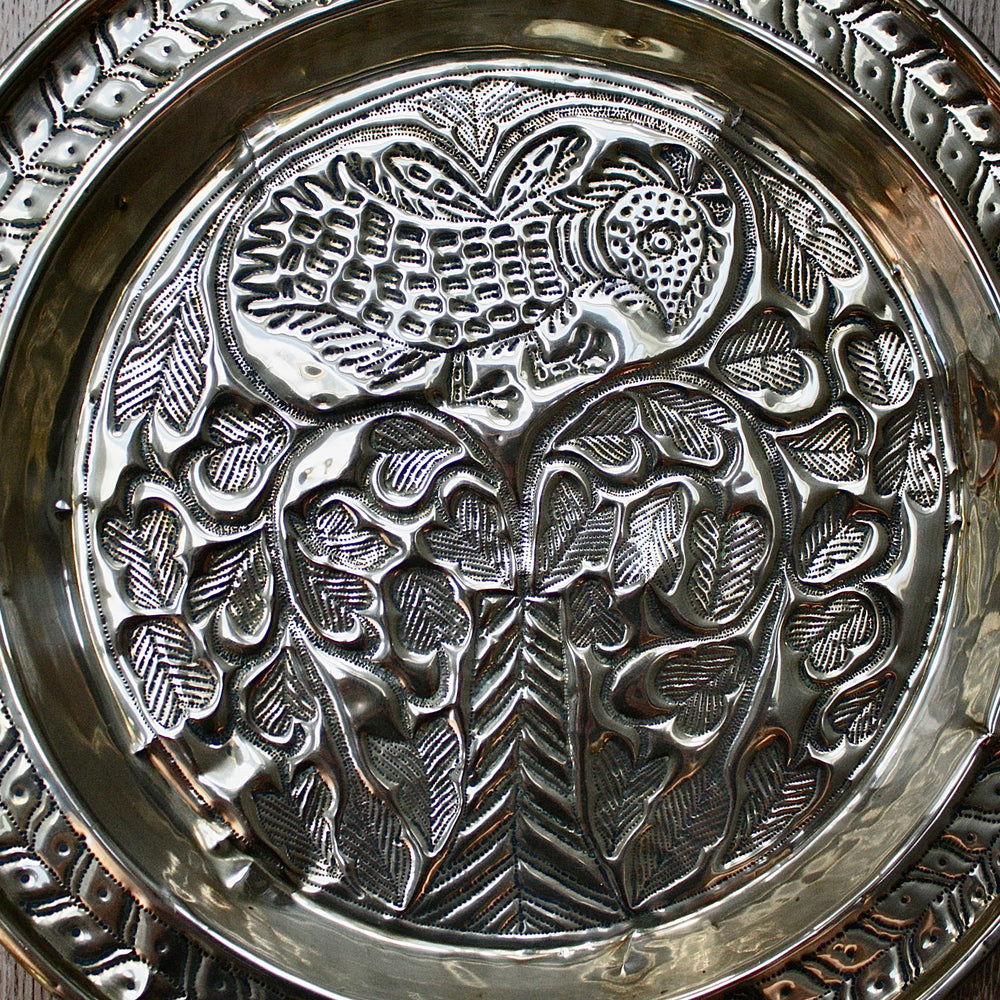 
                  
                    an old calabar charger decorated with a bird in a tree.
                  
                