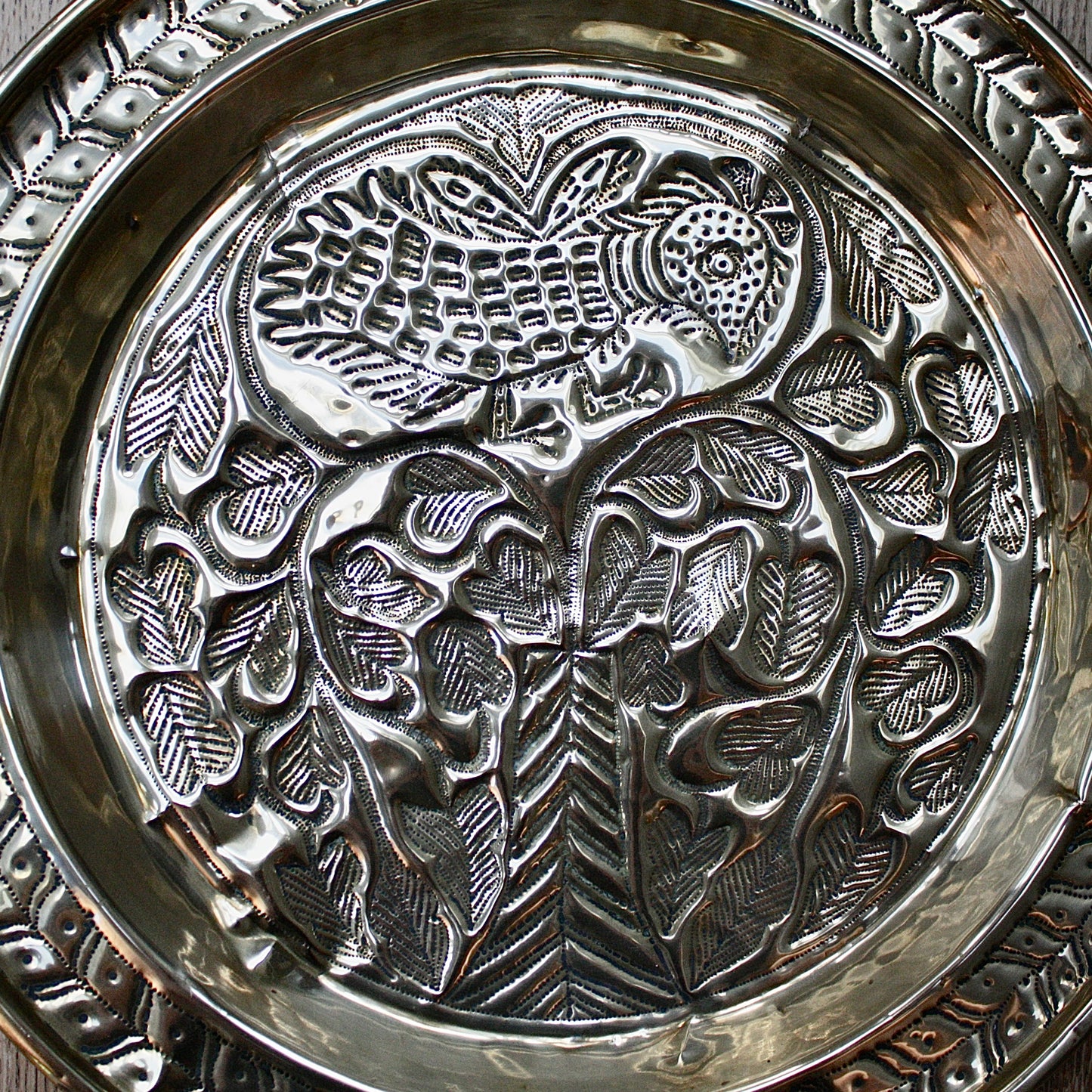
                  
                    an old calabar charger decorated with a bird in a tree.
                  
                