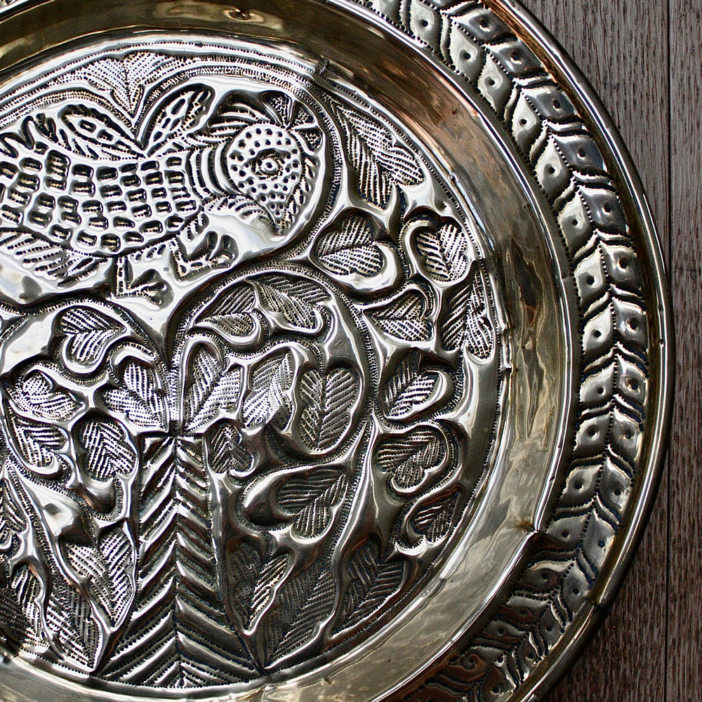 
                  
                    an old calabar charger decorated with a bird in a tree.
                  
                