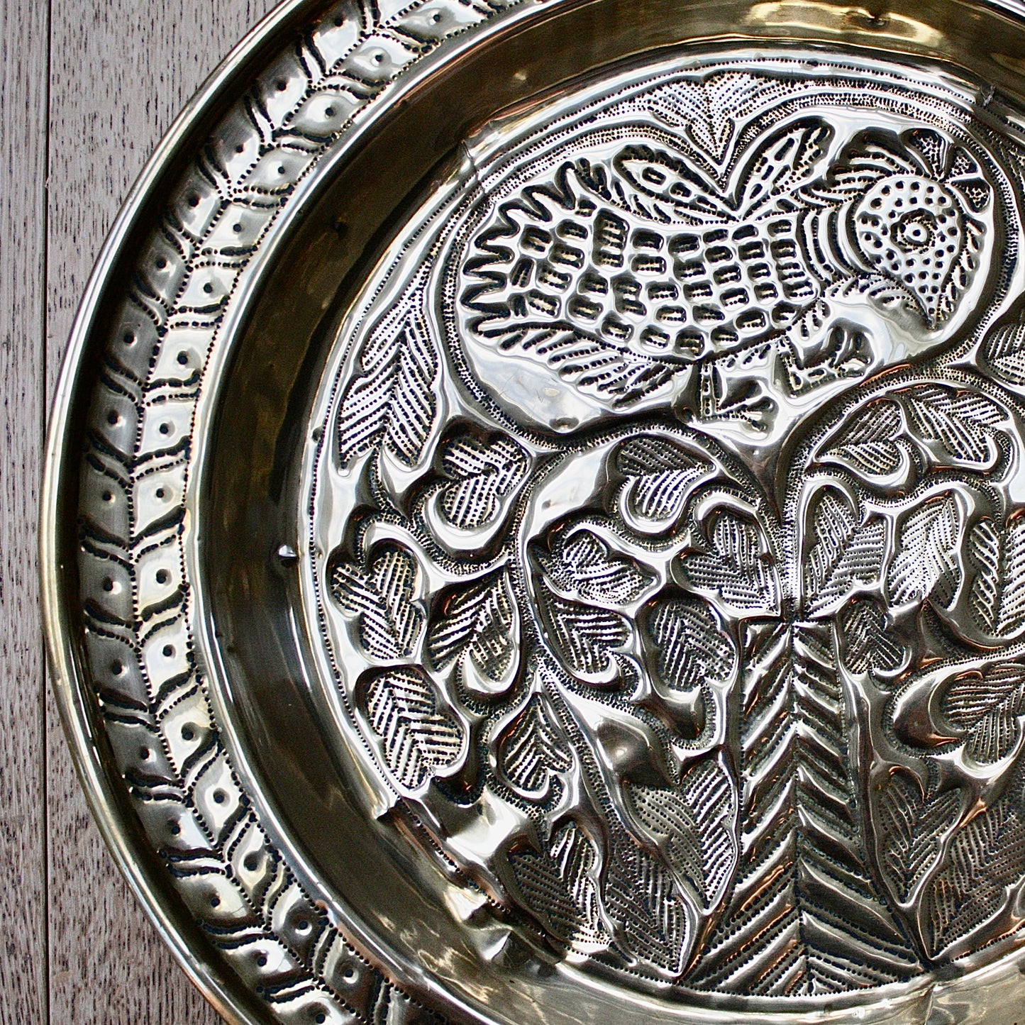 
                  
                    an old calabar charger decorated with a bird in a tree.
                  
                