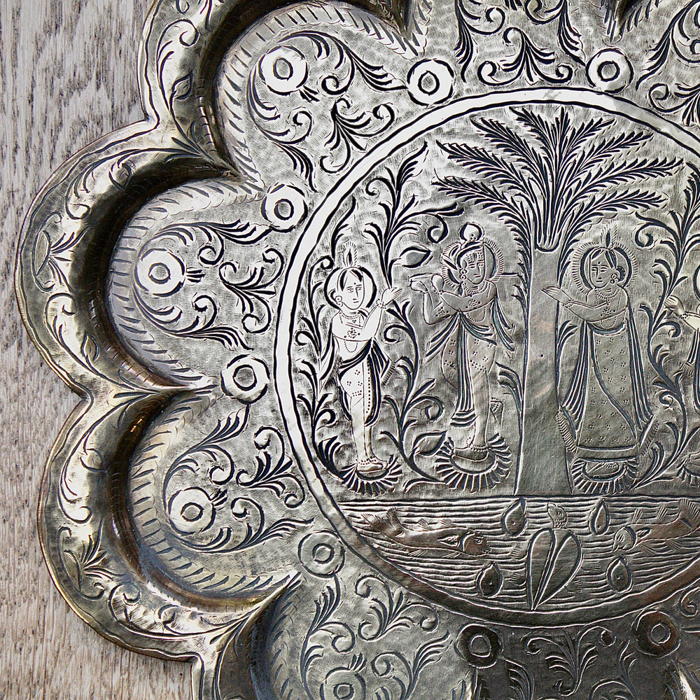 
                  
                    an antique Indian engraved brass thali.
                  
                