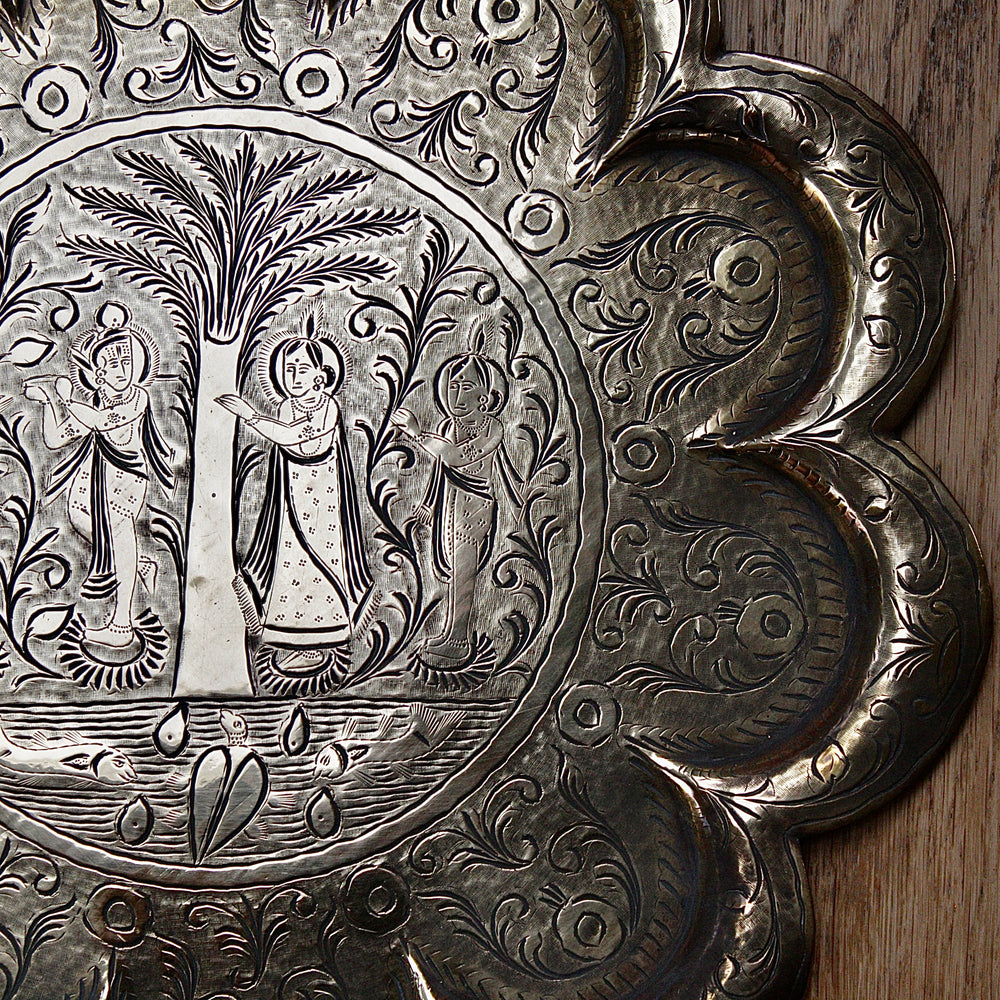 
                  
                    an antique Indian engraved brass thali.
                  
                