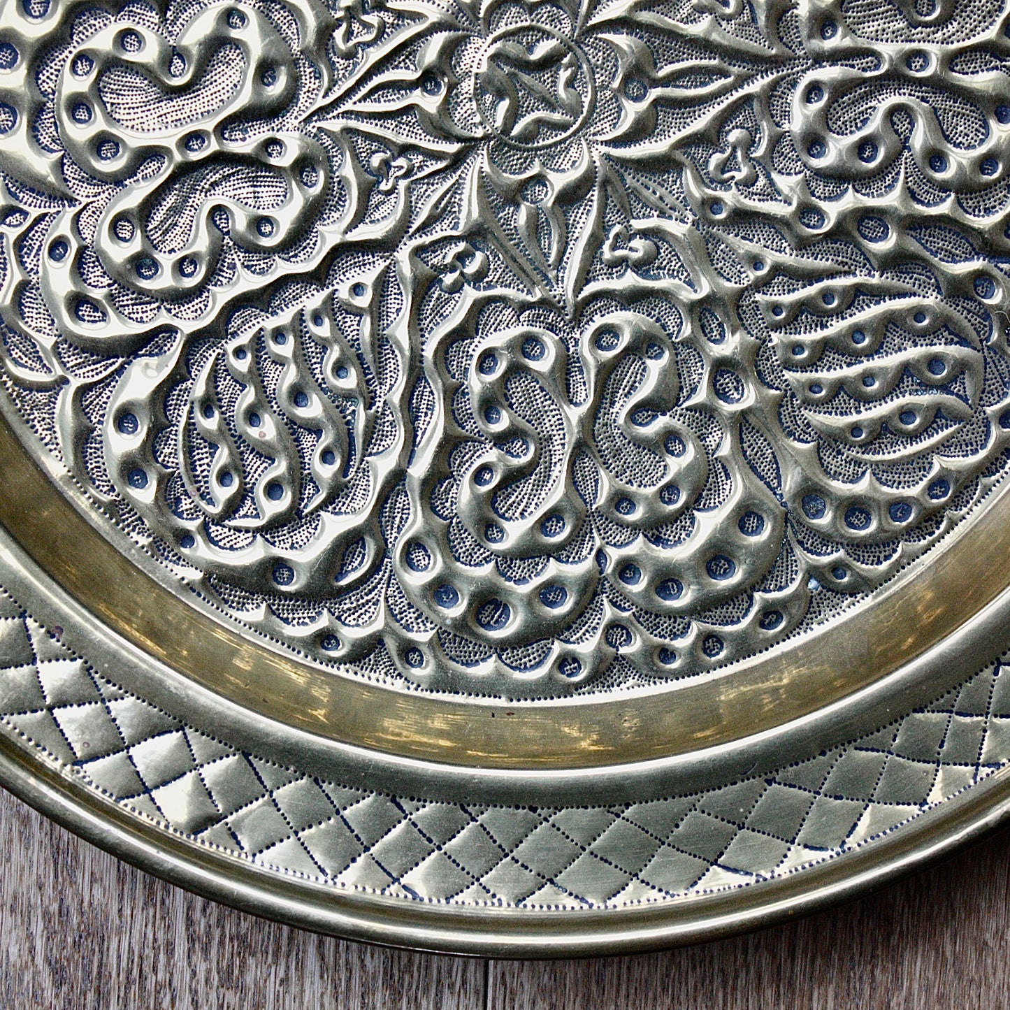 
                  
                    an african efik brass charger decorated with wild plants.
                  
                