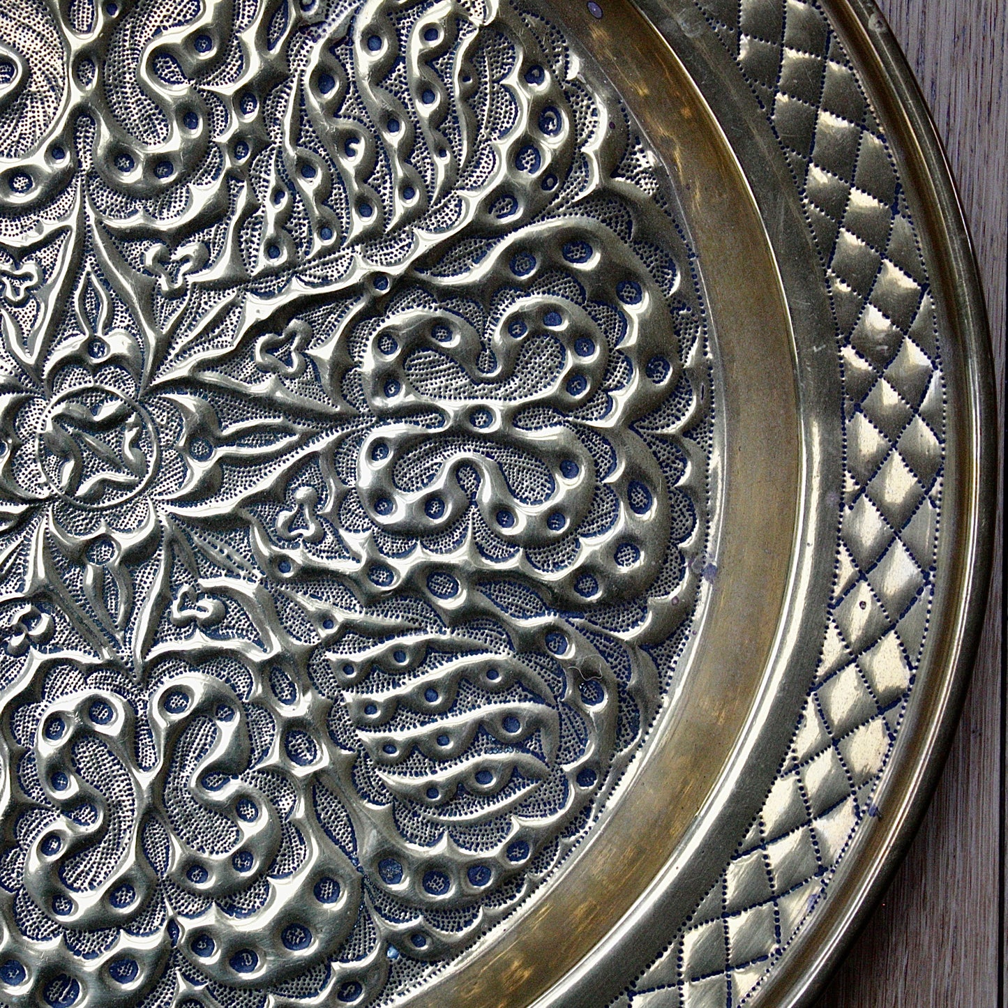 
                  
                    an african efik brass charger decorated with wild plants.
                  
                