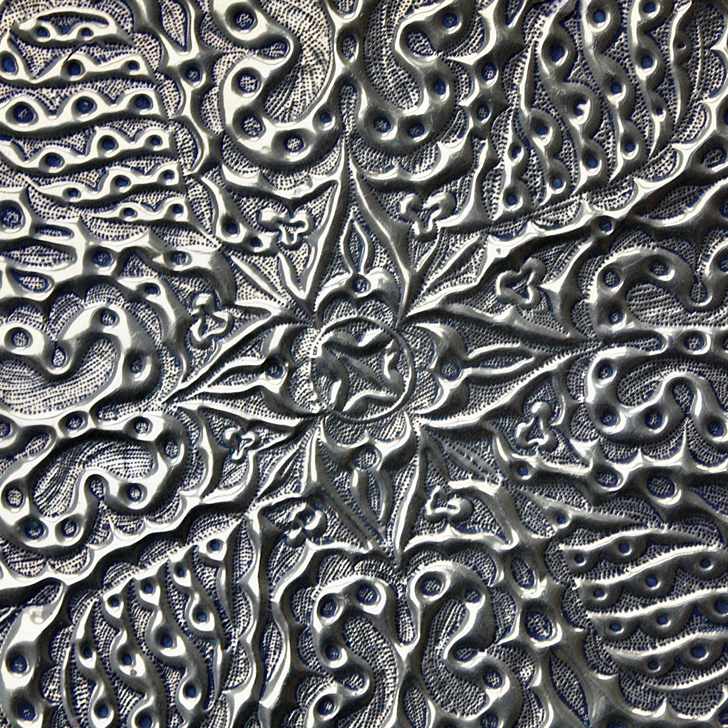 
                  
                    an african efik brass charger decorated with wild plants.
                  
                