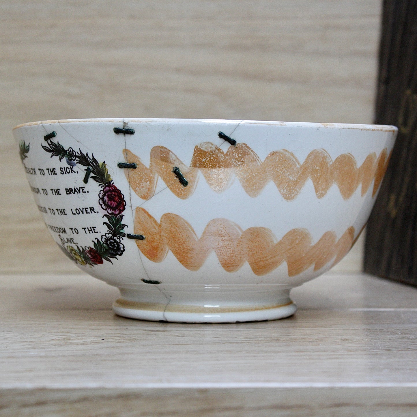 
                  
                    a glorious sunderland orange lustre bowl with an impressive staple repair.
                  
                