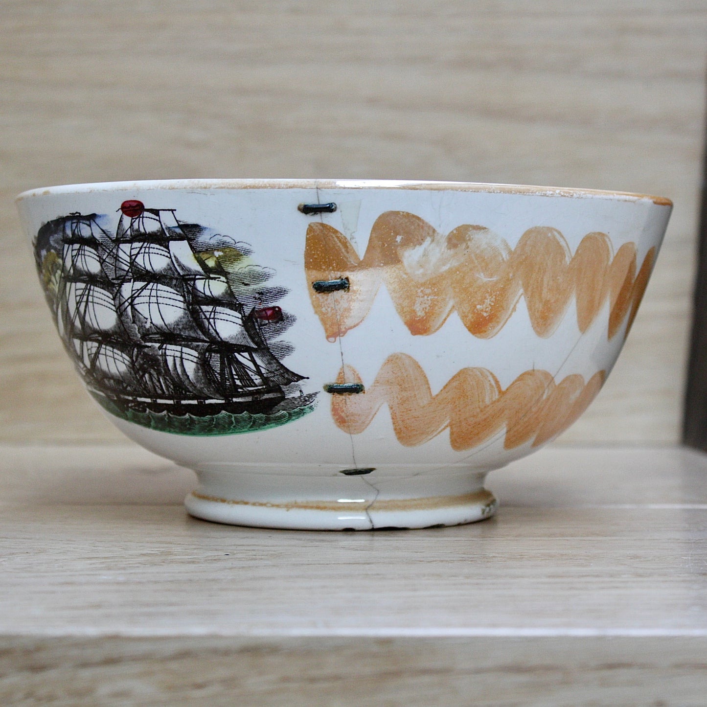 
                  
                    a glorious sunderland orange lustre bowl with an impressive staple repair.
                  
                