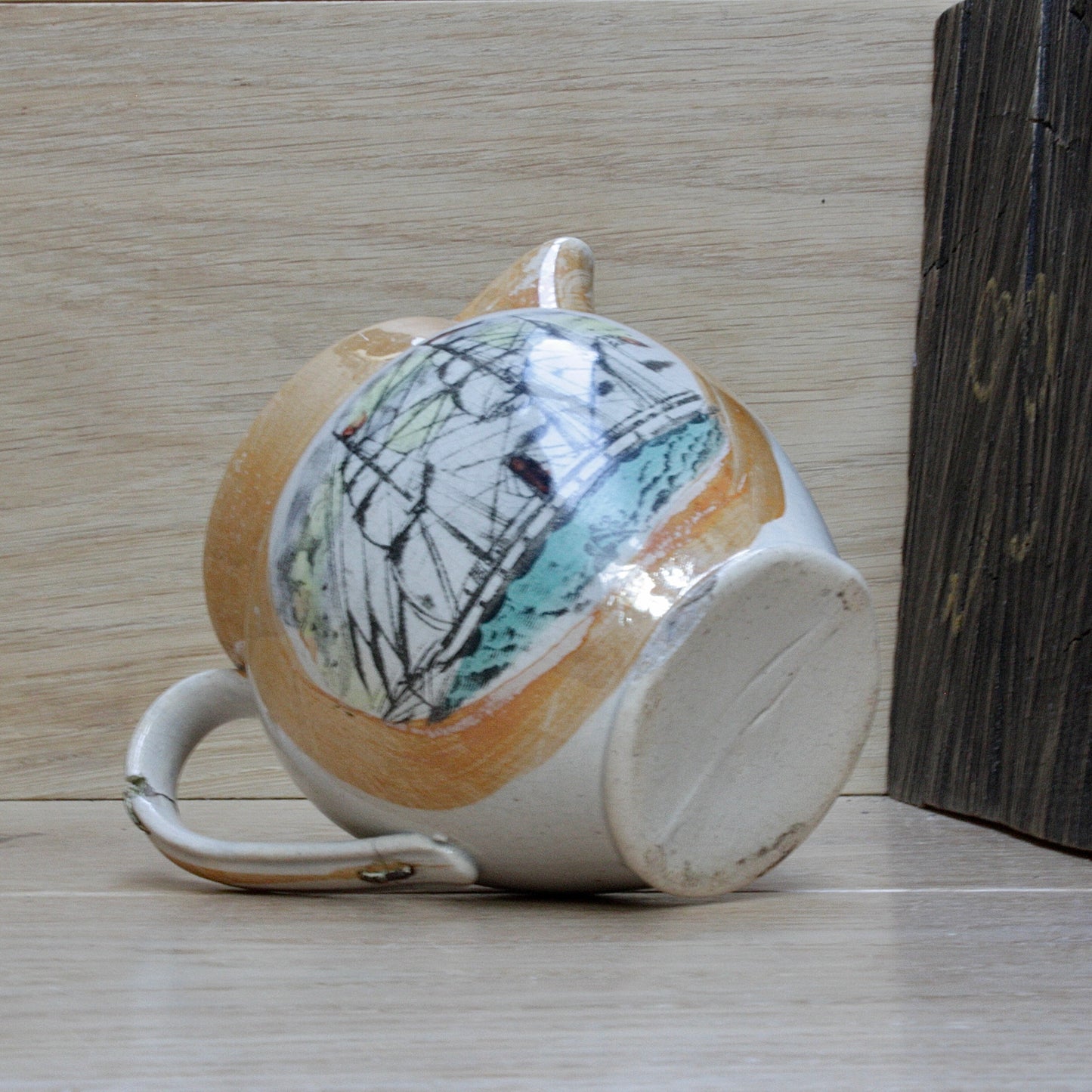 
                  
                    a small antique sunderland orange lustre jug with staple repair.
                  
                