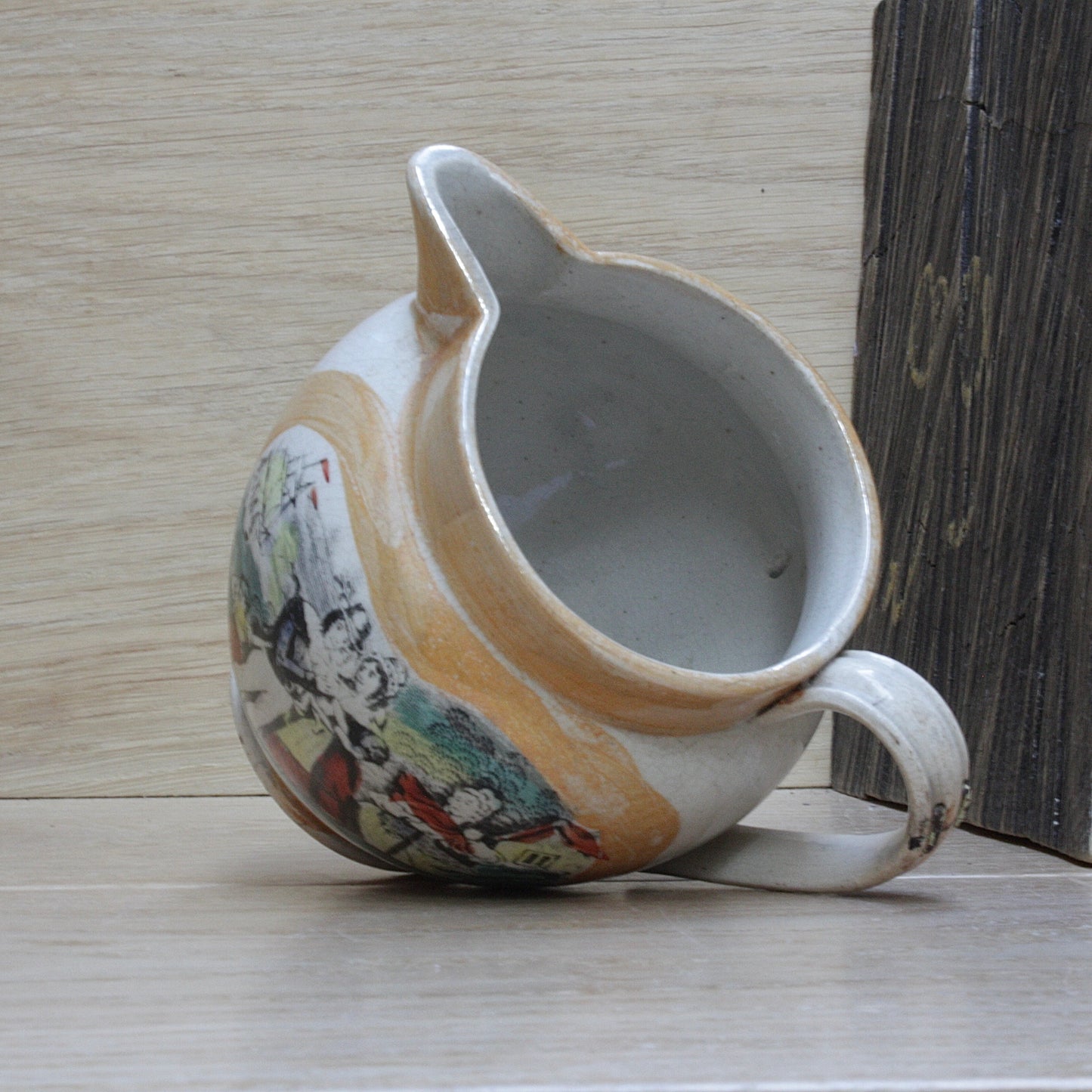 
                  
                    a small antique sunderland orange lustre jug with staple repair.
                  
                