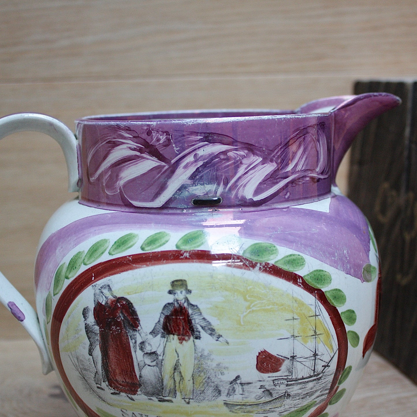 
                  
                    a large antique purple sunderland lustre jug with a single staple repair.
                  
                