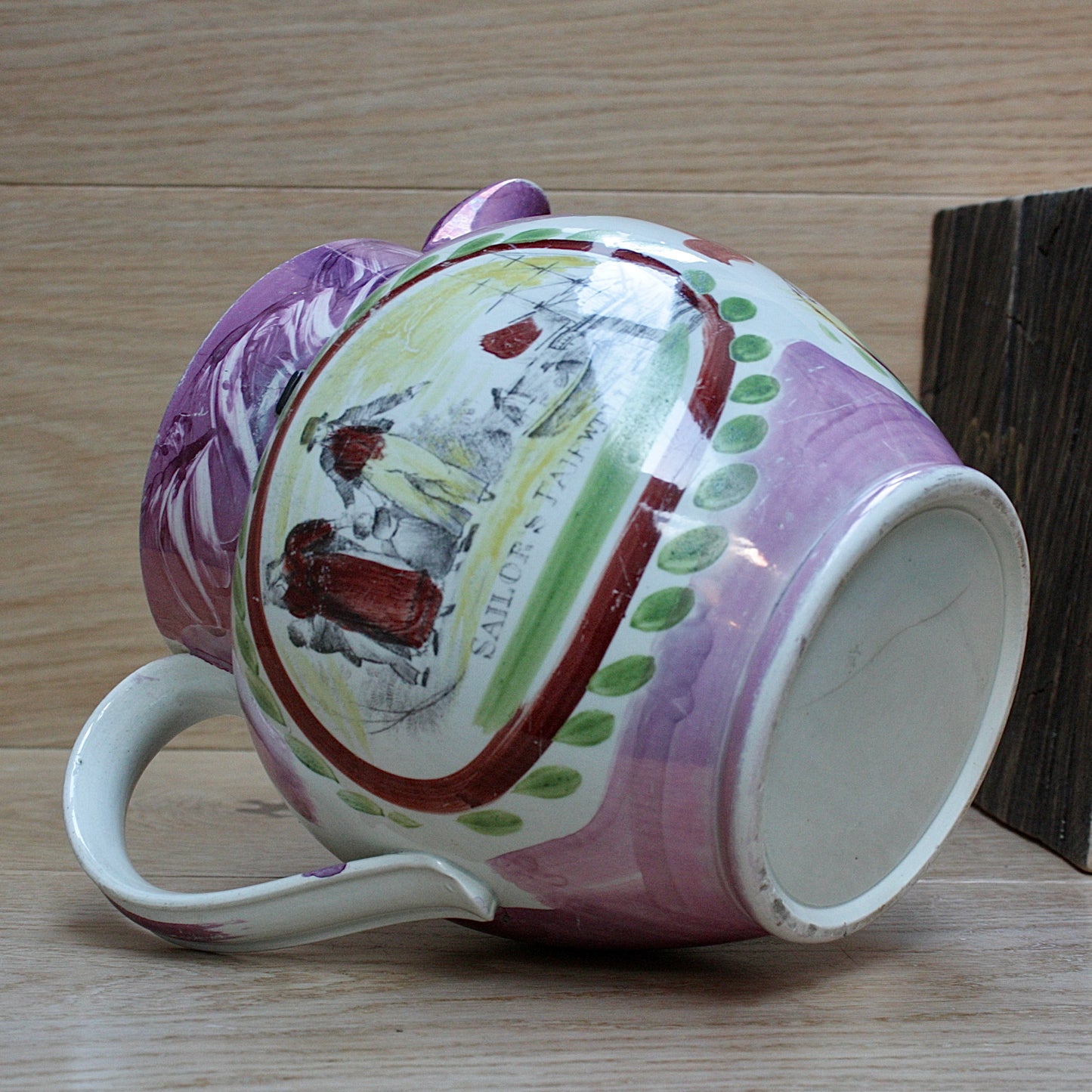 
                  
                    a large antique purple sunderland lustre jug with a single staple repair.
                  
                