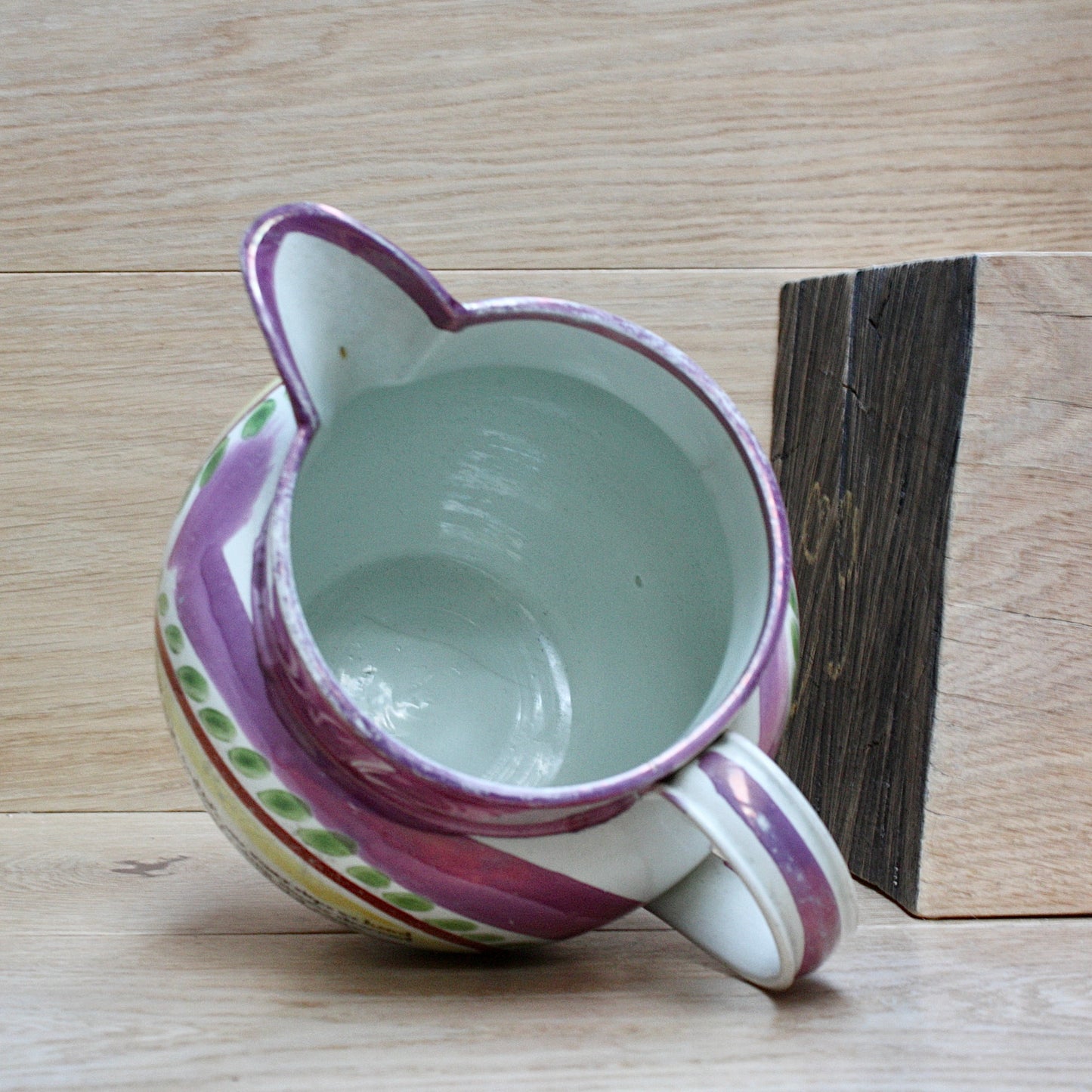 
                  
                    a large antique purple sunderland lustre jug with a single staple repair.
                  
                