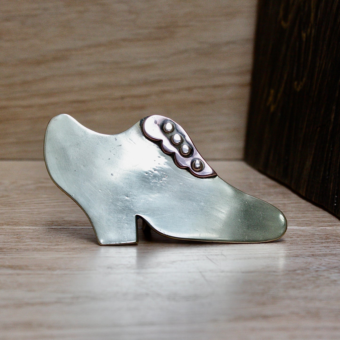 
                  
                    a small antique folk art mantlepiece brass shoe.
                  
                