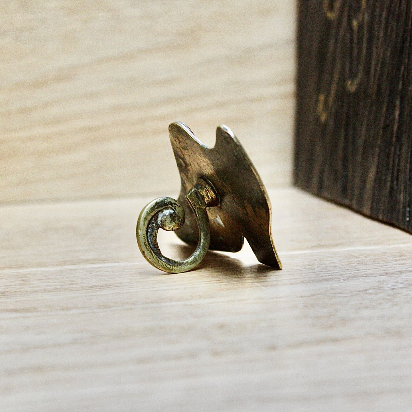 
                  
                    a small antique folk art mantlepiece brass shoe.
                  
                