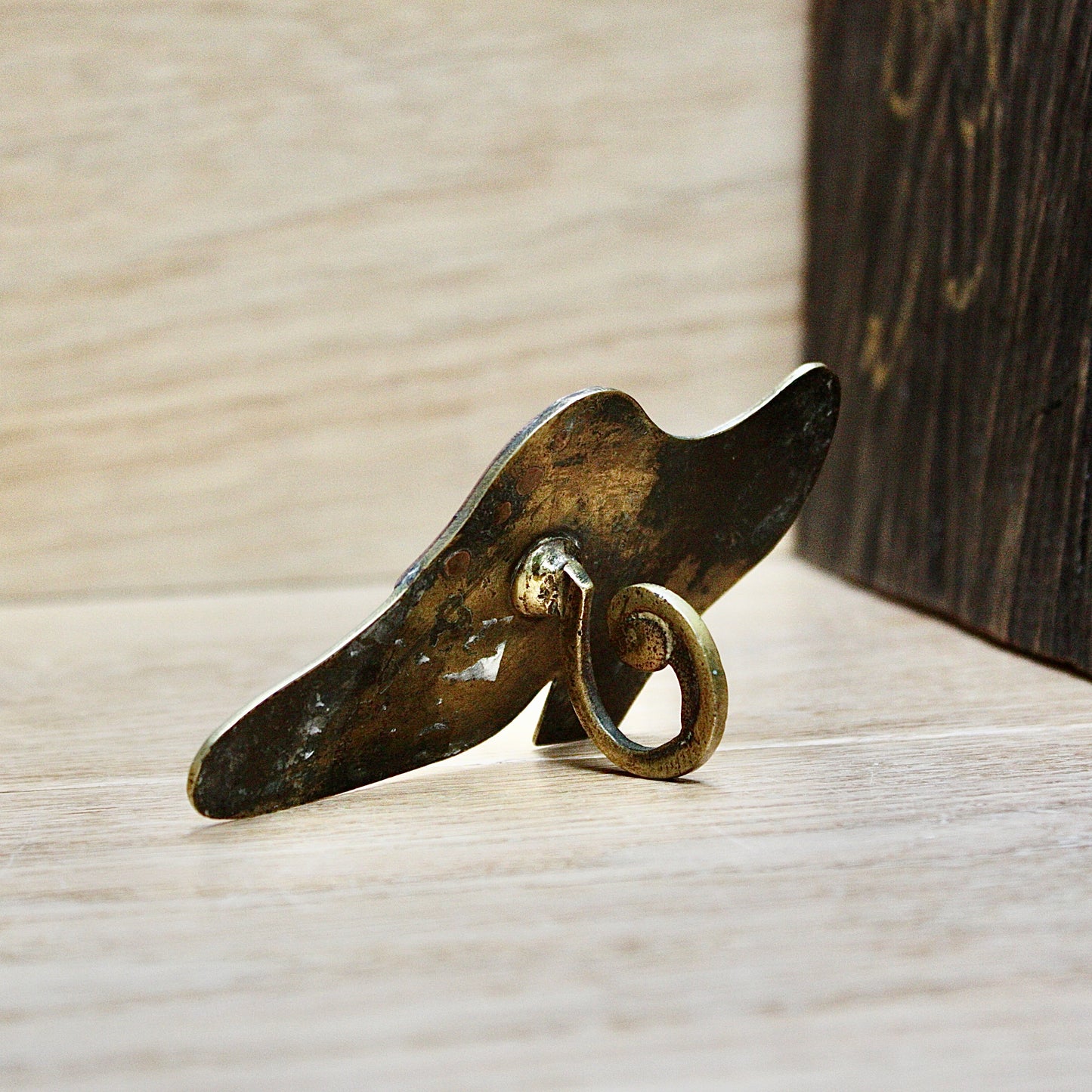 
                  
                    a small antique folk art mantlepiece brass shoe.
                  
                