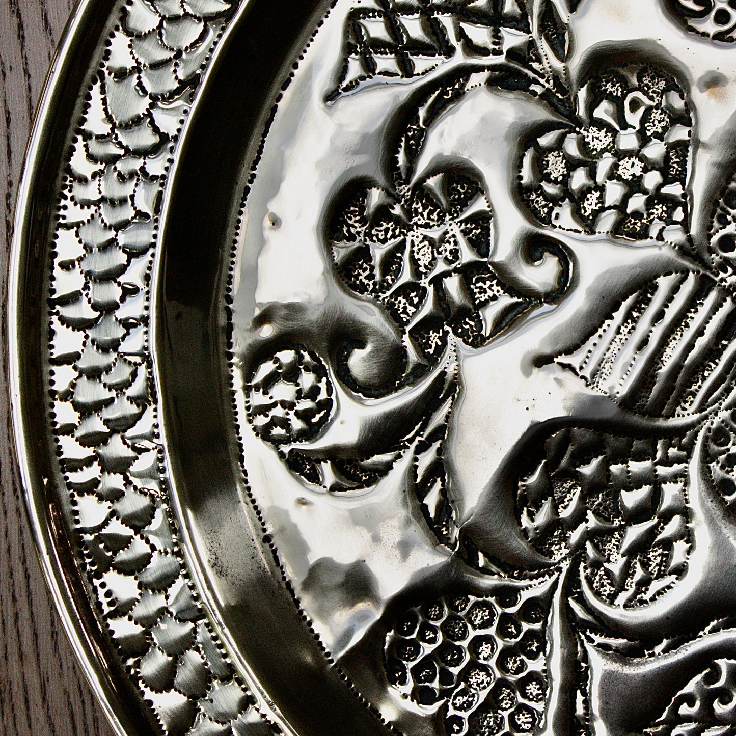 
                  
                    an african efik brass charger decorated with wild plants.
                  
                