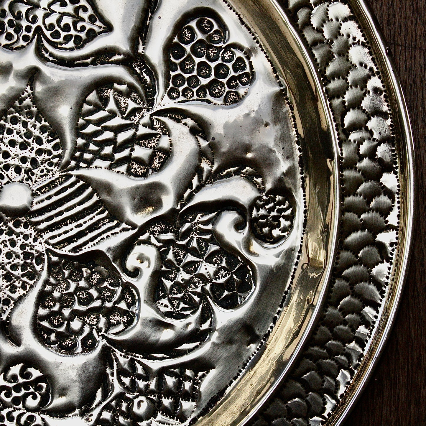 
                  
                    an african efik brass charger decorated with wild plants.
                  
                
