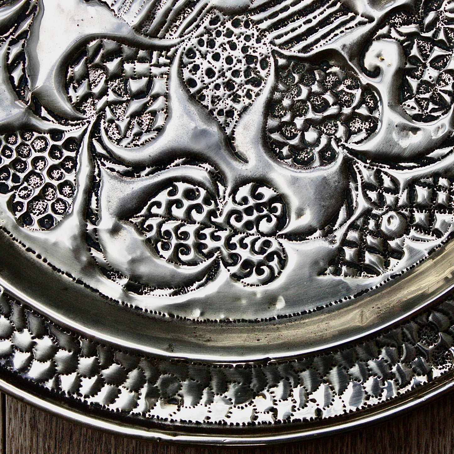 
                  
                    an african efik brass charger decorated with wild plants.
                  
                