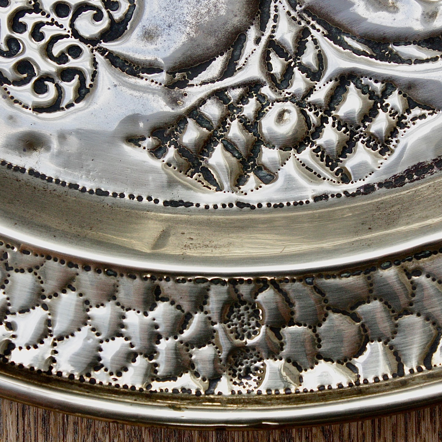 
                  
                    an african efik brass charger decorated with wild plants.
                  
                