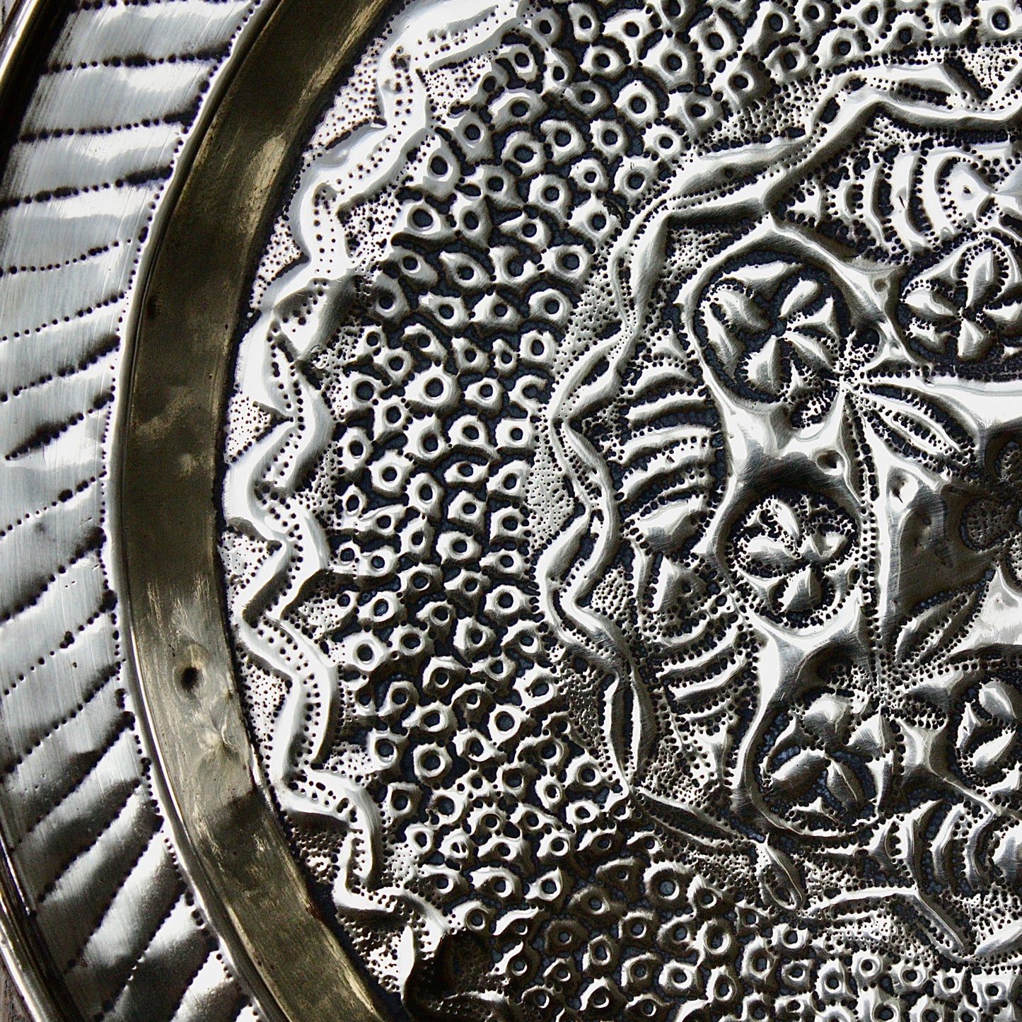 
                  
                    an african efic brass charger decorated with wild plants.
                  
                