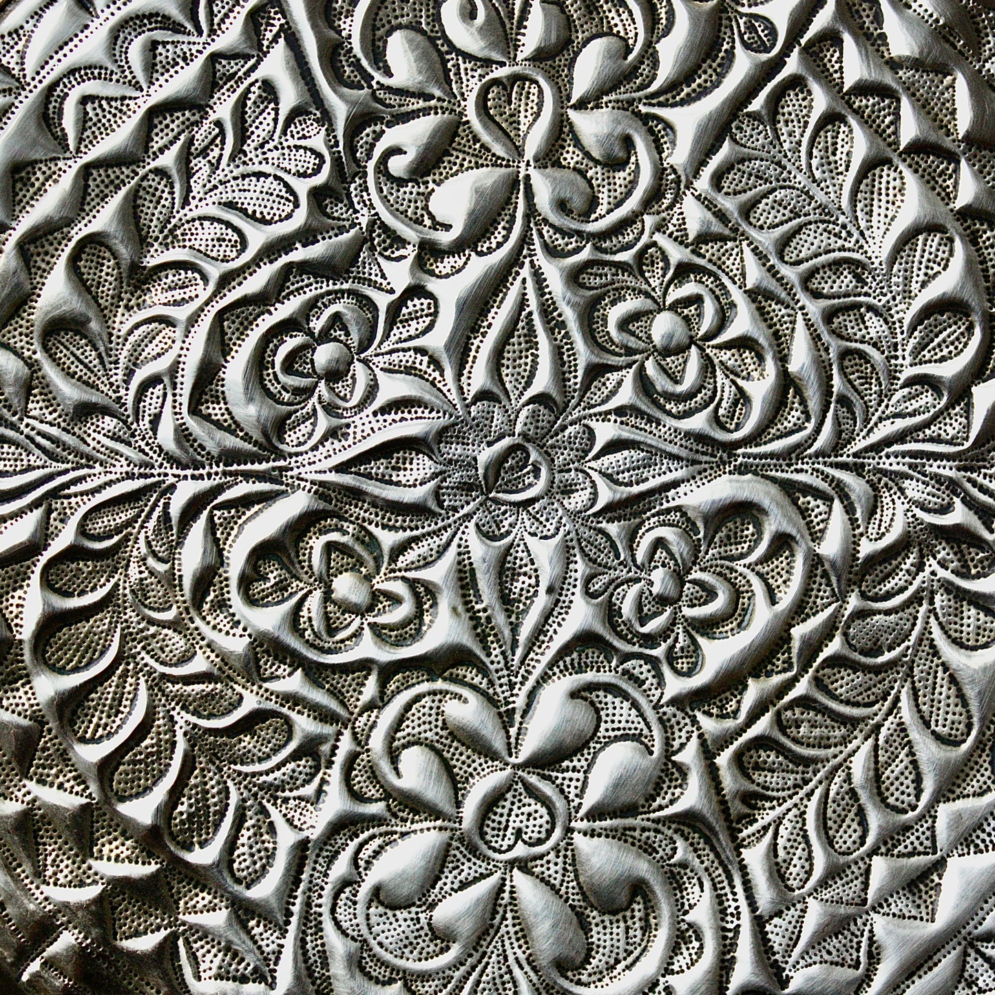
                  
                    an african efik brass charger decorated with wild plants.
                  
                