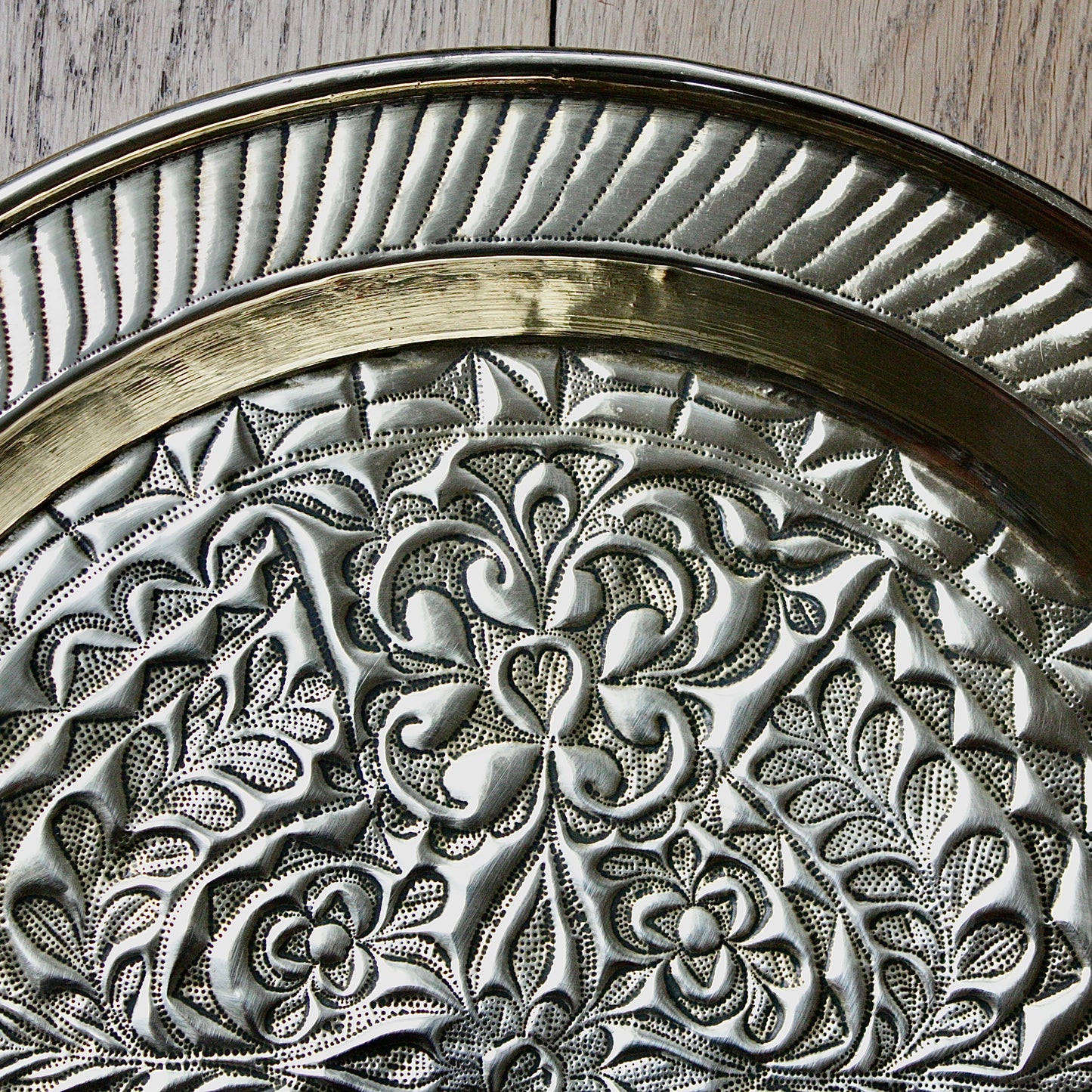 
                  
                    an african efik brass charger decorated with wild plants.
                  
                