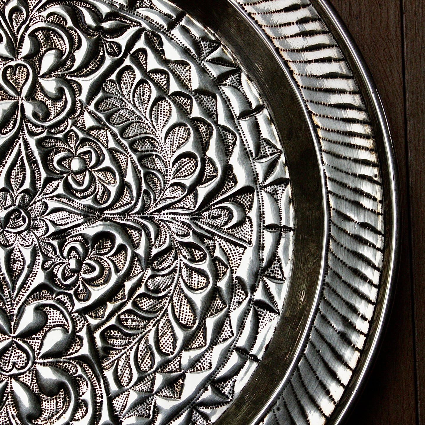 
                  
                    an african efik brass charger decorated with wild plants.
                  
                