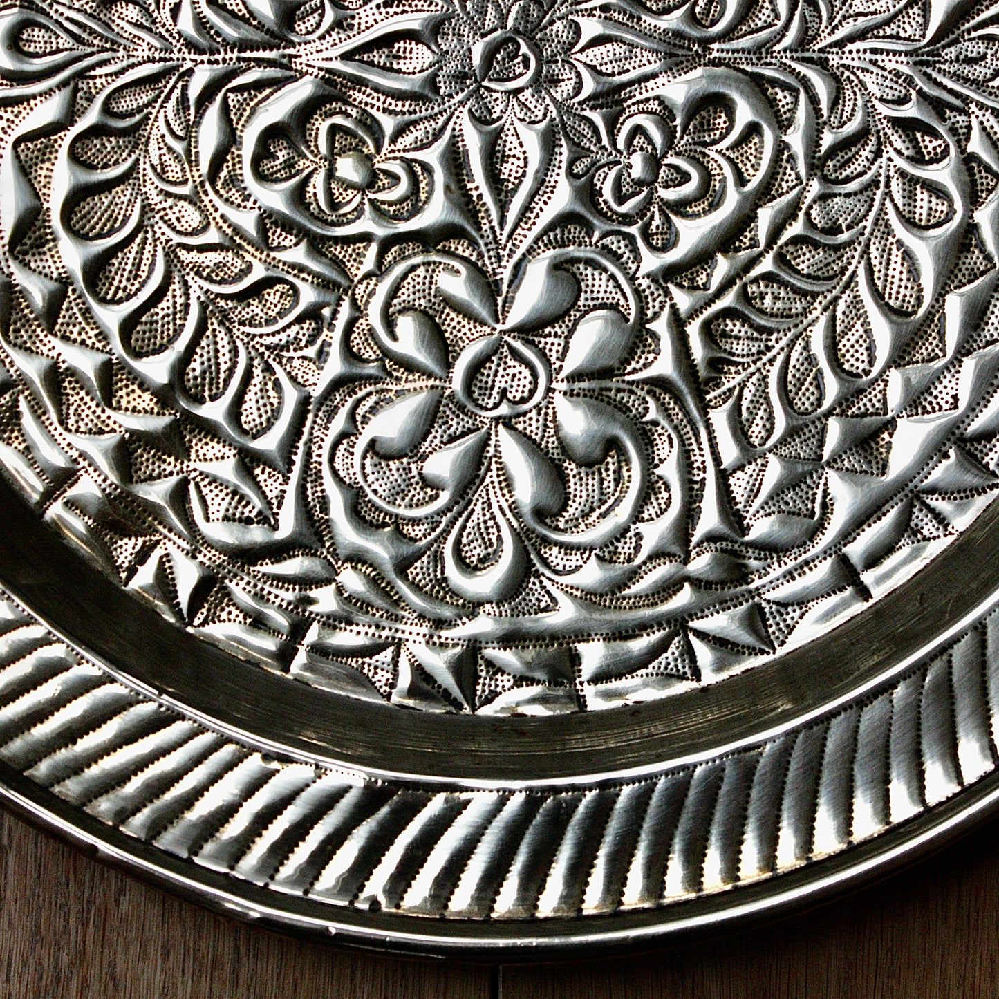 
                  
                    an african efik brass charger decorated with wild plants.
                  
                