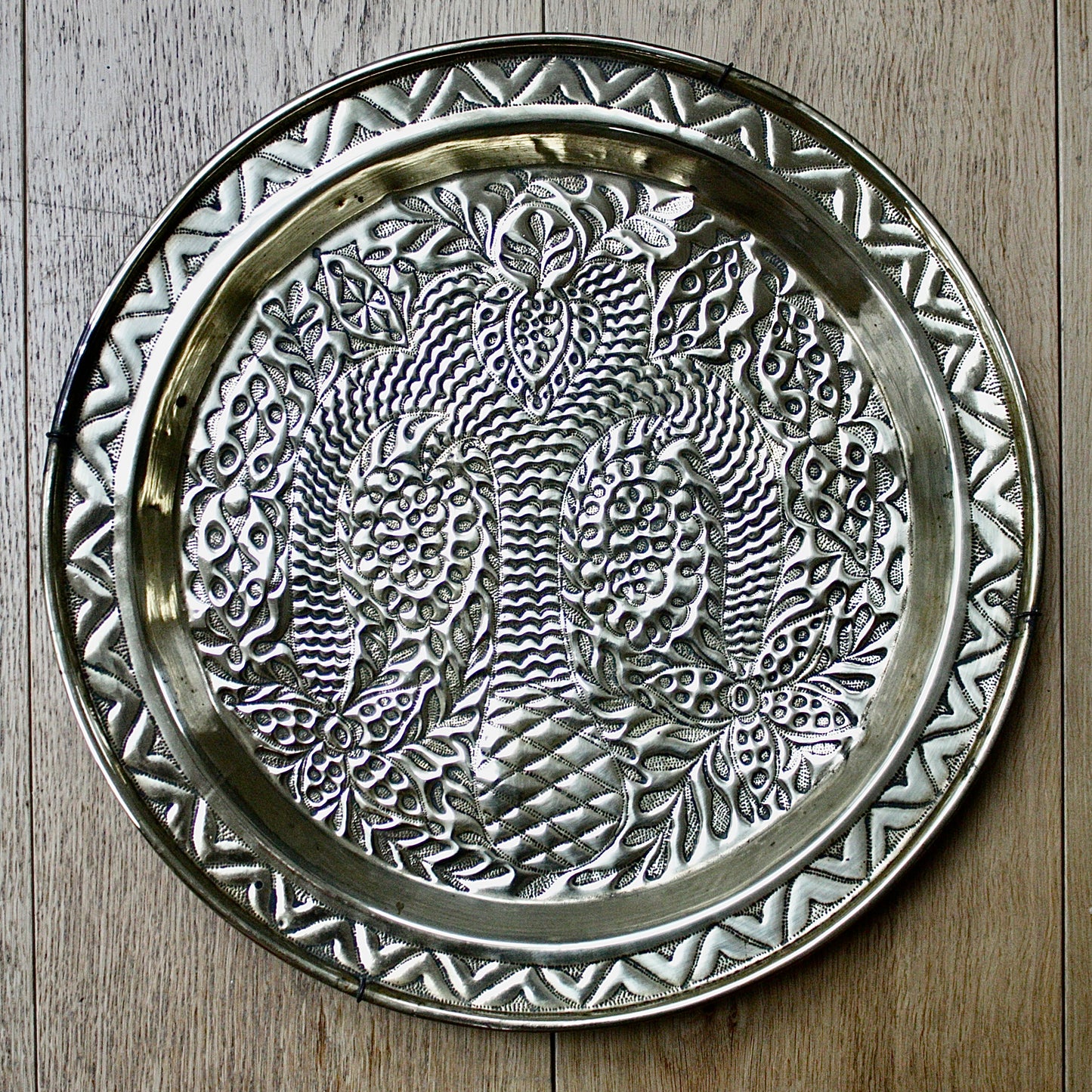 
                  
                    a magnificent african efic brass charger decorated with the bamboo palm
                  
                