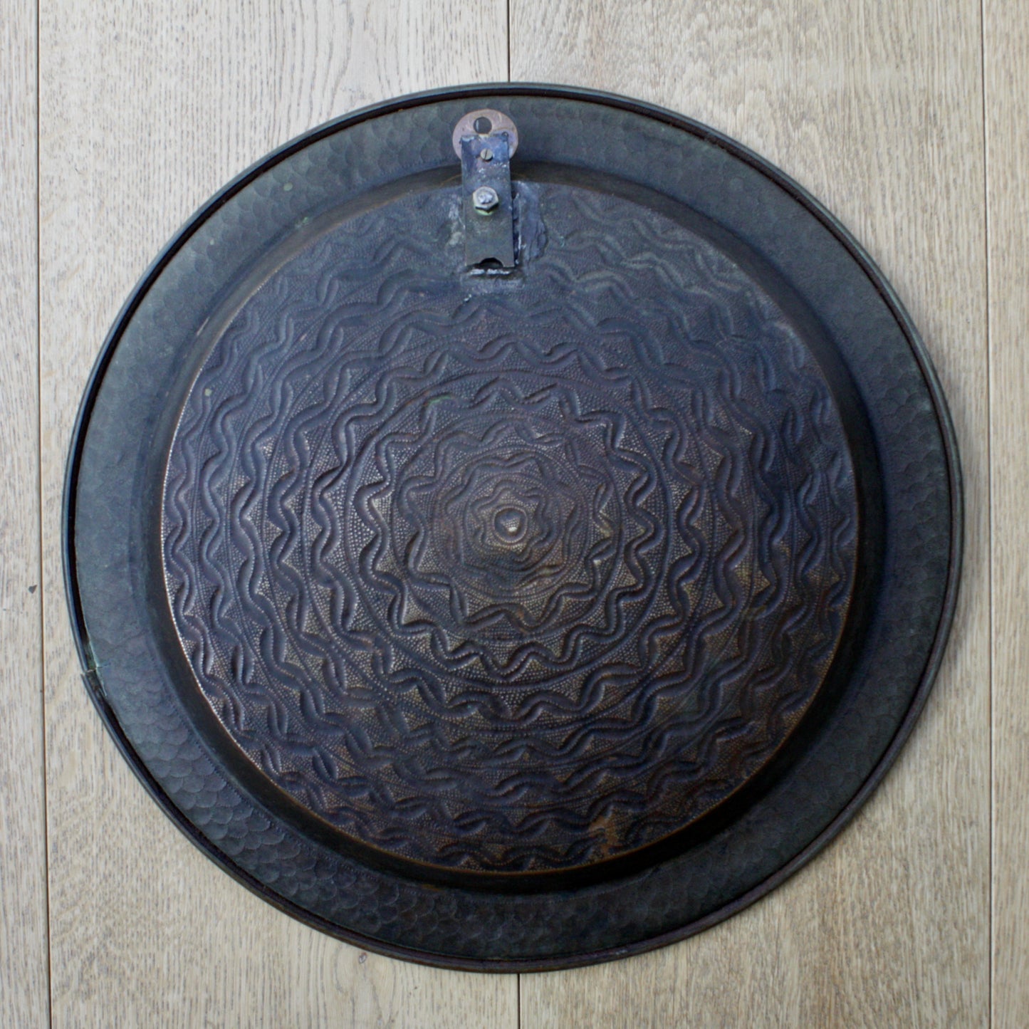 
                  
                    an antique african efic brass charger embossed with geometric patterns
                  
                