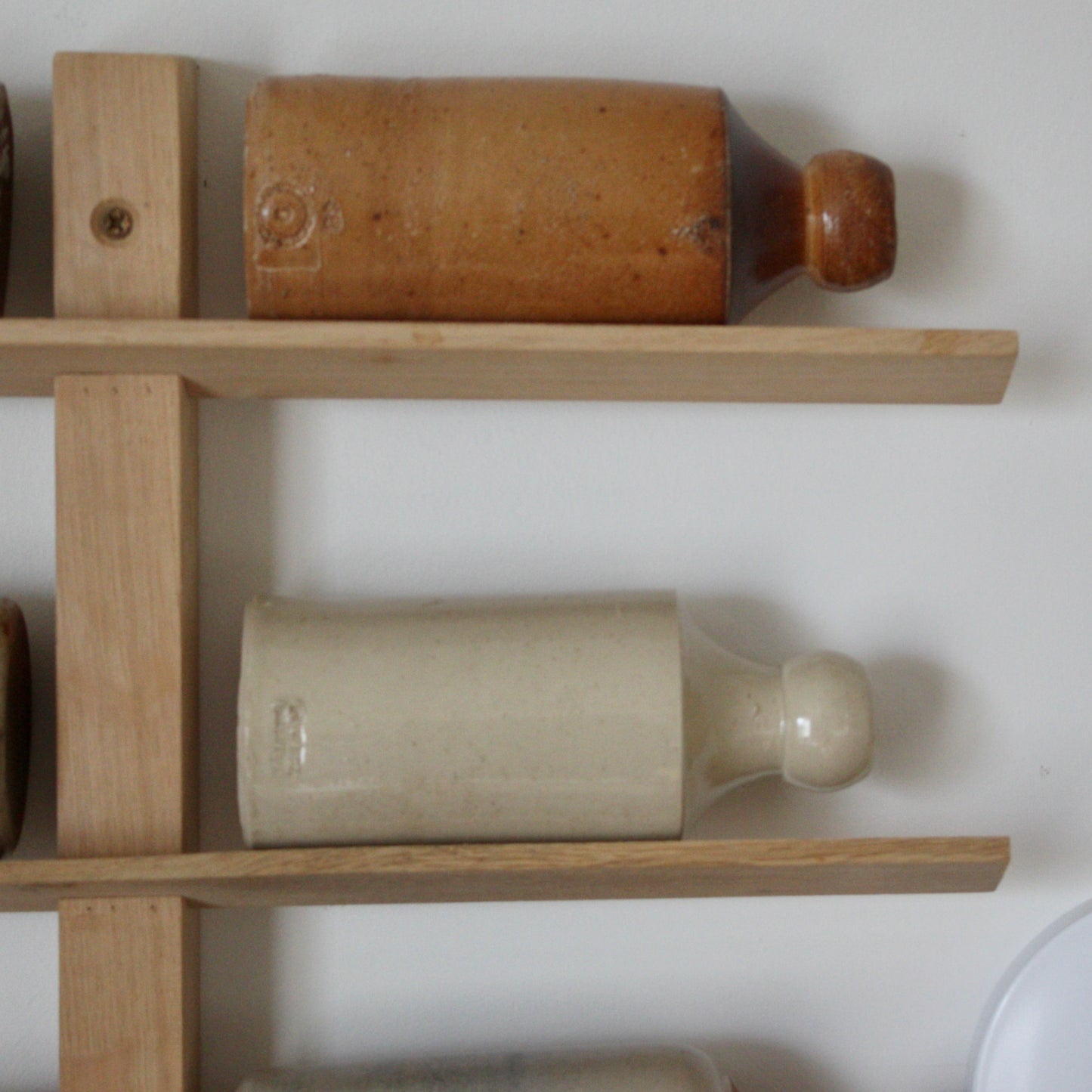 
                  
                    a collection of Antique stoneware bottles along with an oak display rack
                  
                
